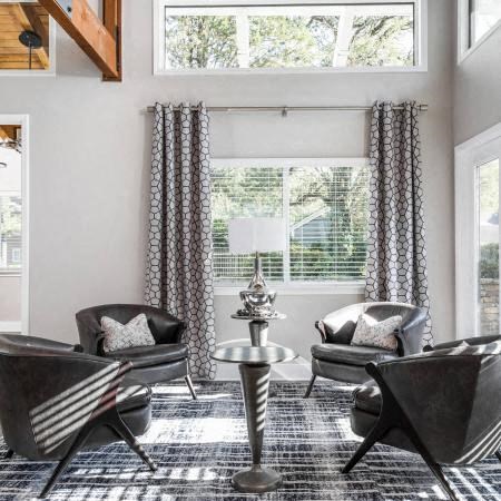 a living room with chairs and a table and a window